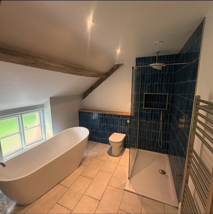 Full bathroom with blue tiled shower and freestanding bath
